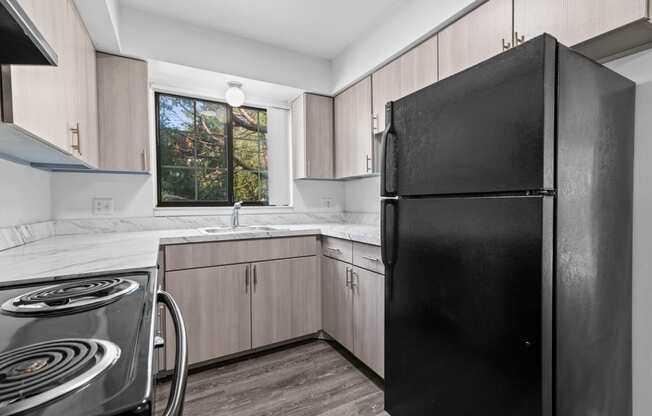 a kitchen with wooden cabinets and a black refrigerator