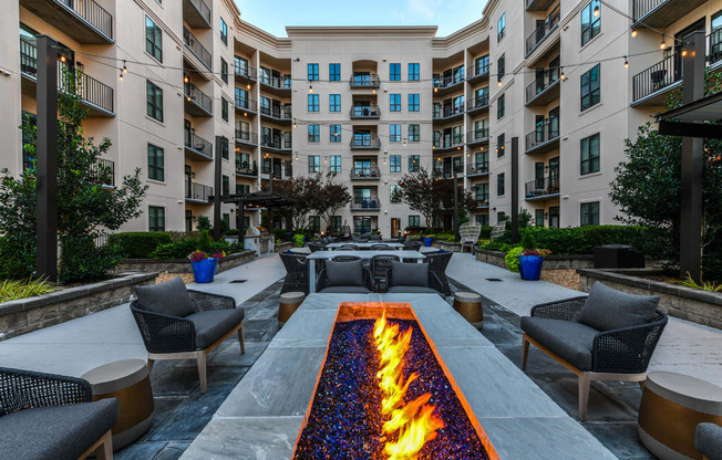 an outdoor patio with a firepit and lounge chairs
