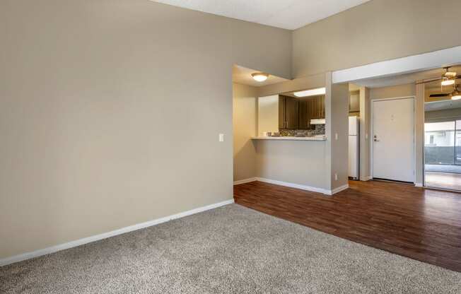 a bedroom with hardwood flooring and a doorway into a kitchen