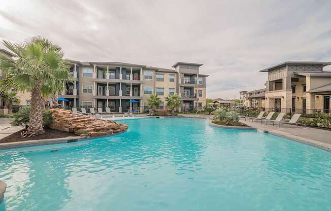 A swimming pool in front of apartment buildings.