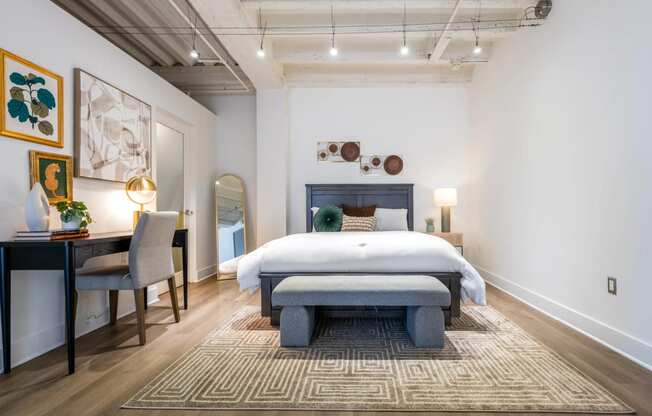 a bedroom with a bed and a desk with a chair