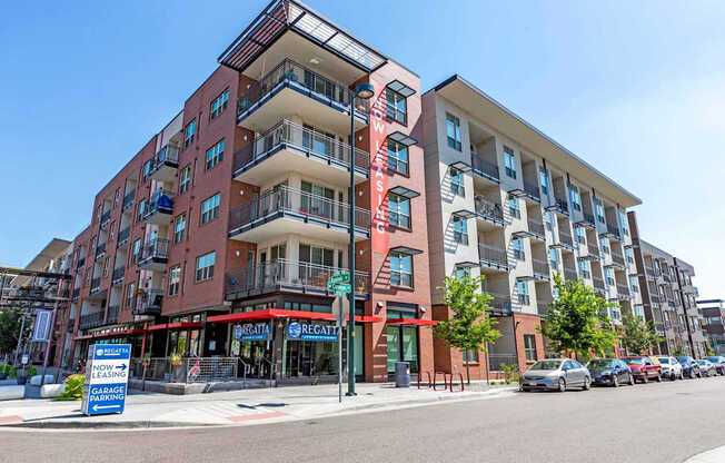 A multi-story apartment building with a red and white sign that says