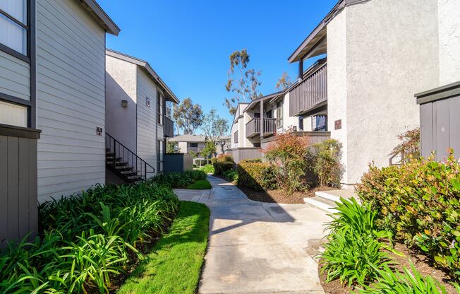 A sunny day in a quiet residential area with a pathway and greenery.