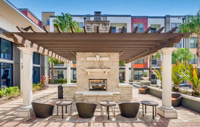 Poolside fireplace under a pergola with seating at EOS in Orlando, FL