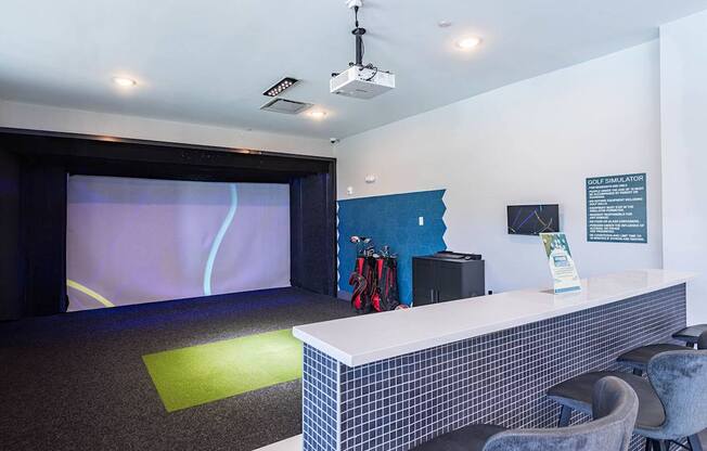 a room with a desk and a projection screen