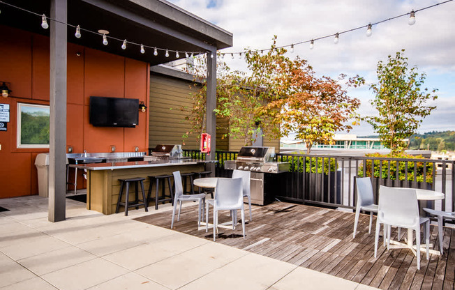A patio with a table and chairs and a TV on the wall. at The Platform, Kent, Washington