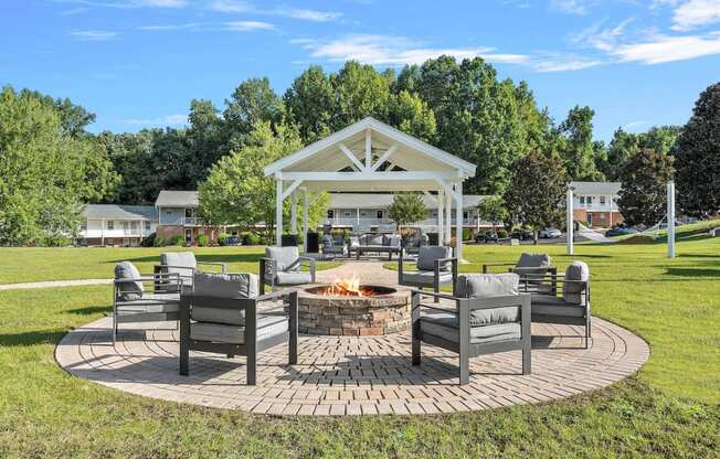 a patio with chairs and a fire pit in a park