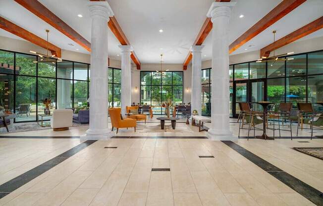 A spacious lobby with white columns and wooden floors.