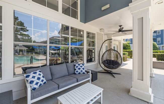 a porch with a couch and a rocking chair and large windows