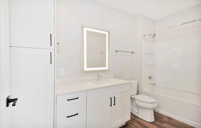 A white bathroom with a toilet, sink, and bathtub.