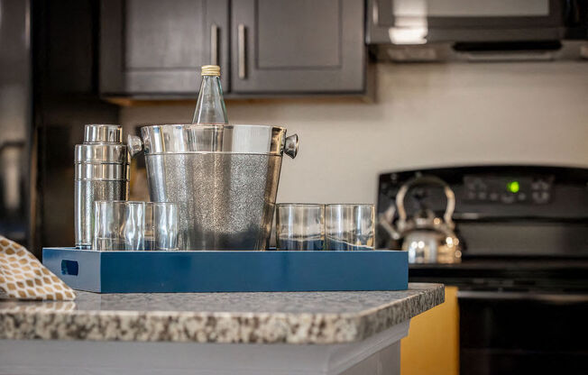 a kitchen counter with glasses and a container on it