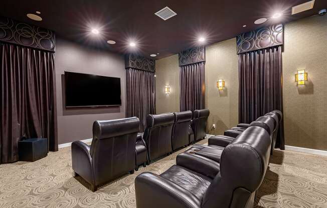 a large screening room with leather seats and a large screen tv