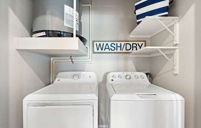 Two white washing machines in a laundry room.