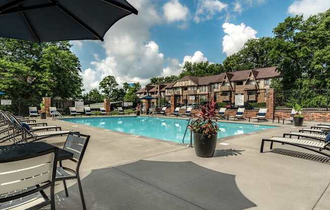 A pool area with a sun umbrella and benches