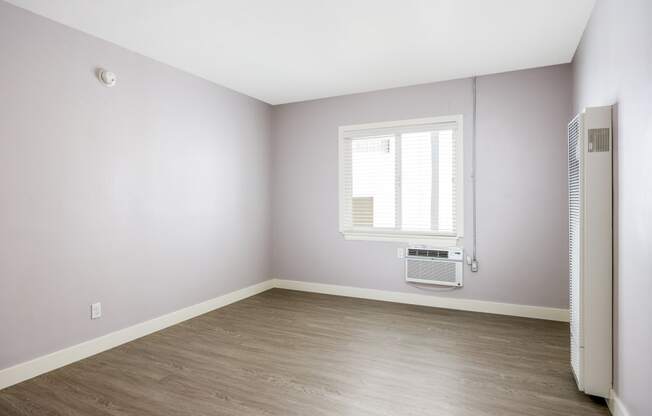 an empty room with a radiator and a window