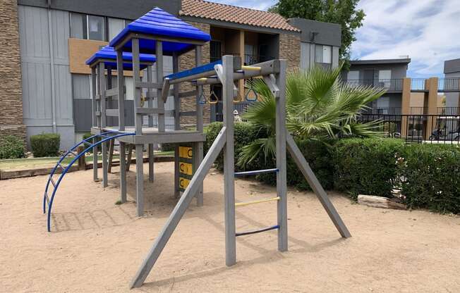 a playground with a swing set in front of a building