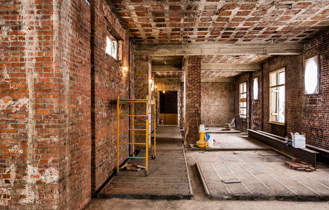 Before: Galley room with exposed brick during renovations
