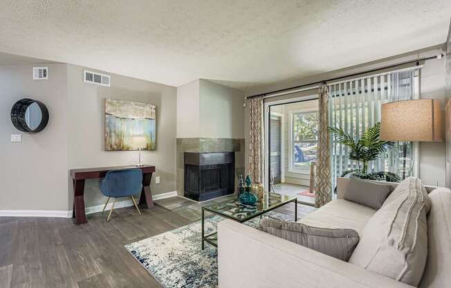 A living room with a couch, a table, and a fireplace.
