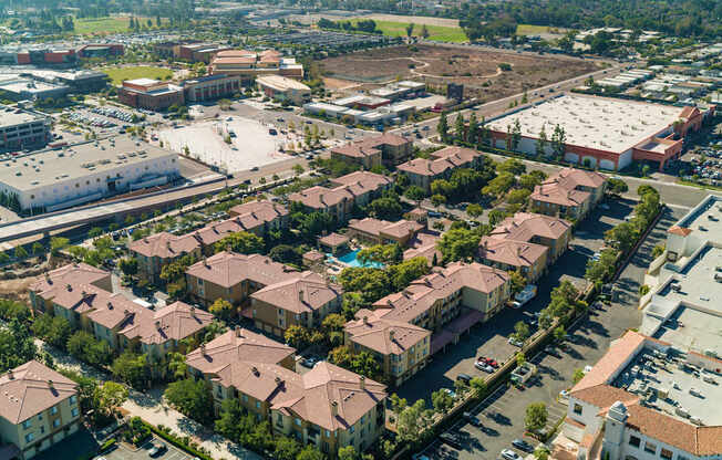A bird's eye view of a residential area with houses and a parking lot.