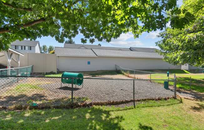 the backyard of a house with a tennis court and a fence