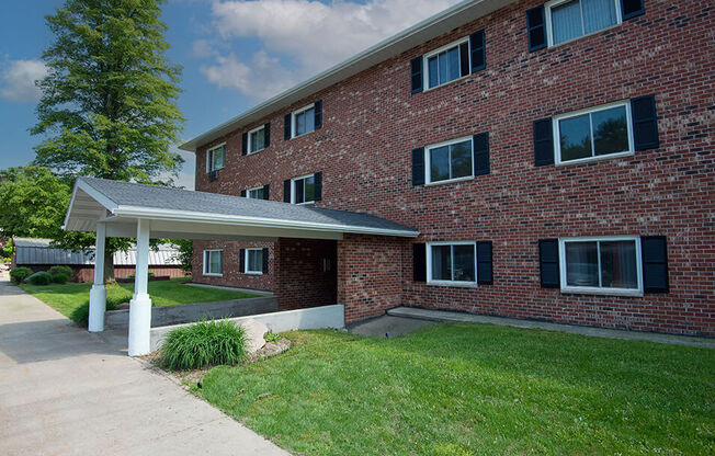 a large brick apartment building with a covered walkway in front of it