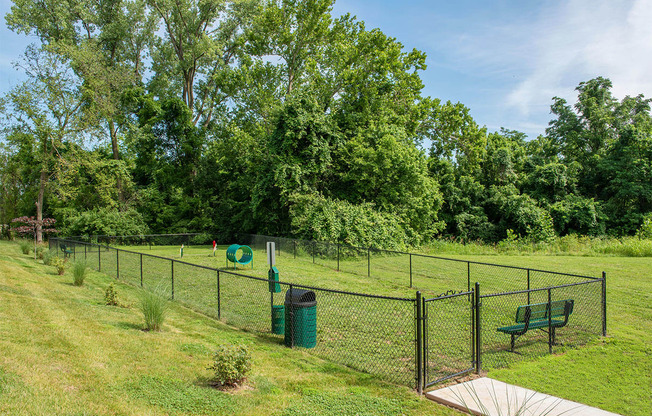 a fenced in area with a frisbee in it and a park bench