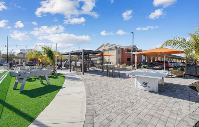 A white table tennis table is in the middle of a paved area.