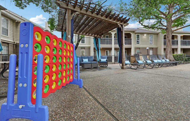 A large blue and red foosball table in the middle of a courtyard.