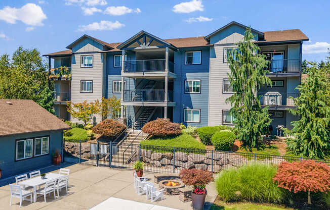 A large apartment complex with a patio and outdoor furniture.