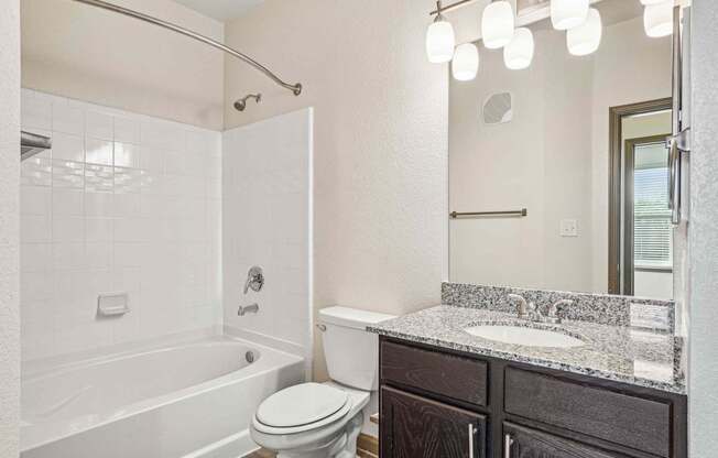 Pet-Friendly Rentals in Bentonville, AR – Parc at Bentonville – A white bathroom with a toilet, sink, and bathtub.