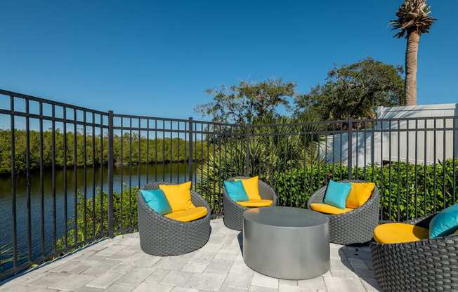 an outdoor patio with wicker chairs and a firepit