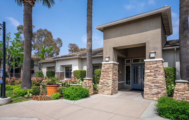 a sidewalk in front of a house with palm trees