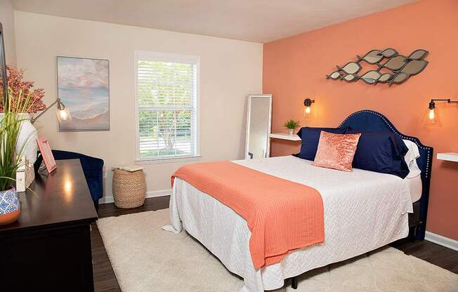 A bedroom with a bed, nightstand, and a painting on the wall.