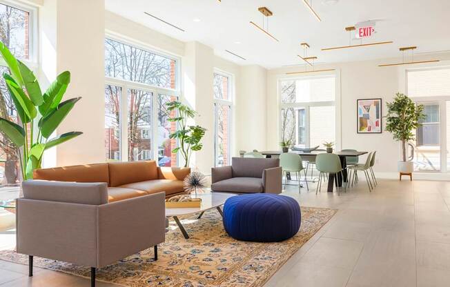 A living room with a brown couch and a blue ottoman.