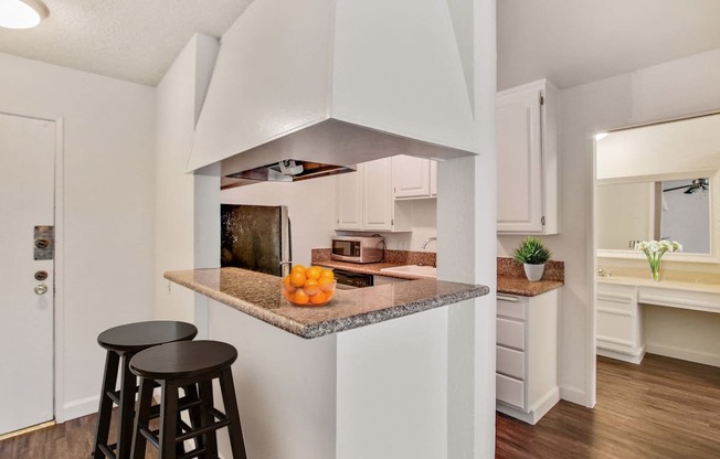 Kitchen with stainless steel appliances, breakfast bar with granite countertops, white kitchen cabinets