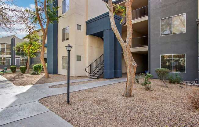 A tree in front of a building with a black lamp post.