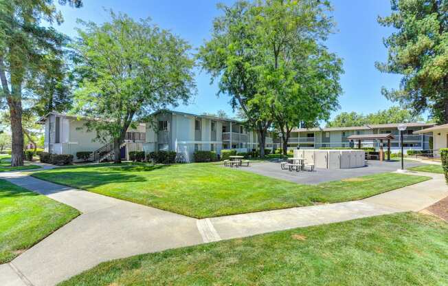 Exterior of the building with large green lawns, walk ways and Trees at Renaissance Park Apartments, Davis, CA, 95618