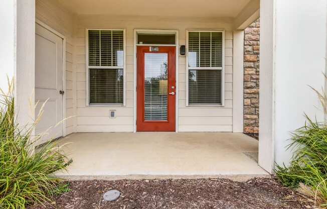 the entrance to a house with a red door