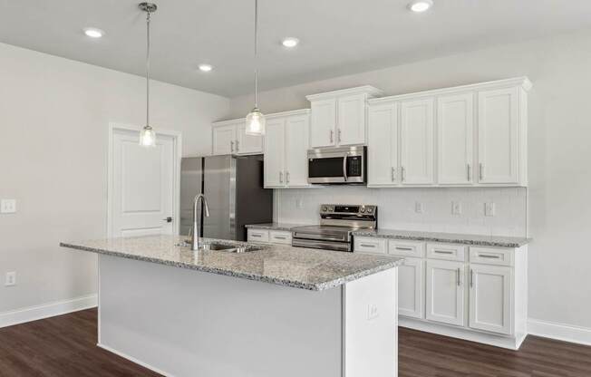 A kitchen with white cabinets and a granite countertop.