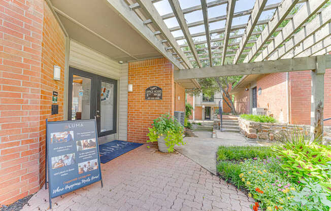 A brick building with a glass roof and a sign in front at Copper Hill Apartments, Bedford, TX, 76021