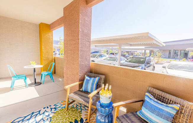 a patio with two chairs and a table and a parking lot