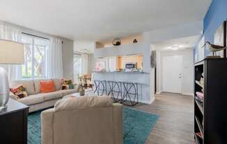 a living room with a kitchen in the background and a couch and chair in the foreground at Heritage Bay, Jensen Beach, FL 34957