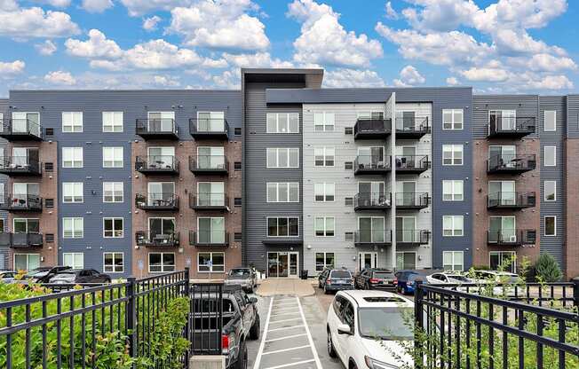 A large apartment complex with a parking lot in front.