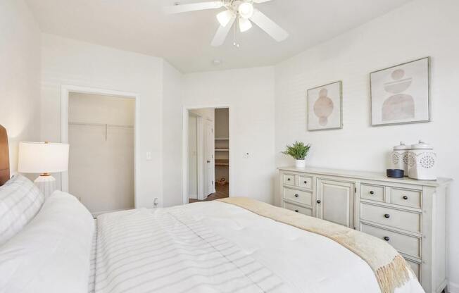 A bedroom with two beds and a ceiling fan.