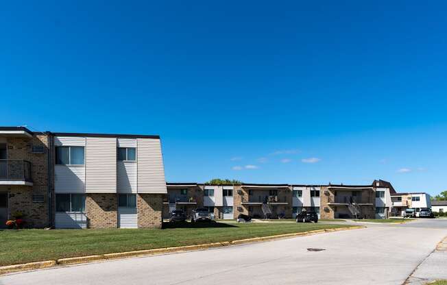 Apartment buildings on a street with a blue sky in the background at Parkwest Gardens West Fargo