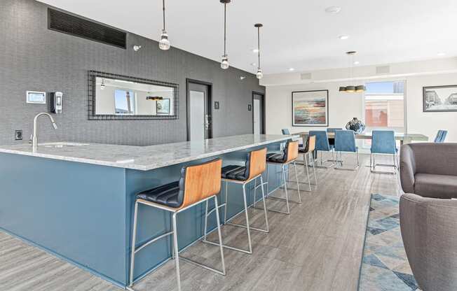 a communal bar with blue stools in a hotel lobby