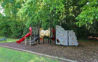 a playground with a slide and other toys in a park at Elea Apartments in Marietta, GA