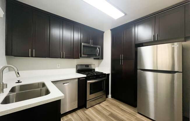 a kitchen with stainless steel appliances and black and white cabinets