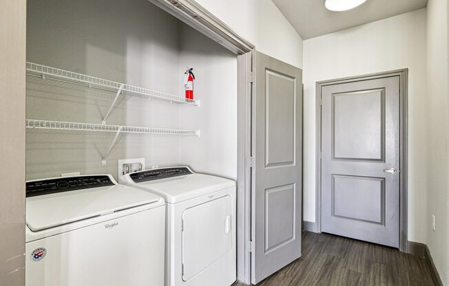 A laundry room with a washer and dryer and a door.
