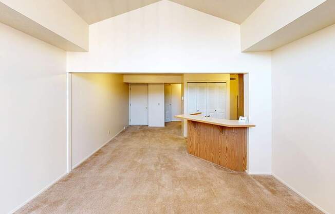 A living room with a cathedral ceiling and plush carpeting at Foxwood and The Hermitage, Portage, MI